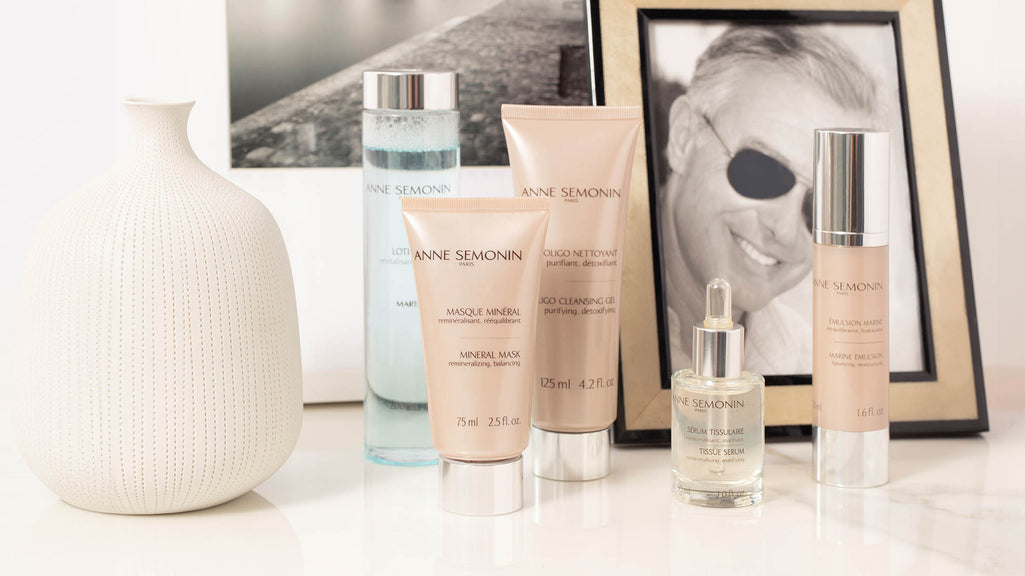 Sélection de produits visage homme posés sur une table à coté d'un visage d'homme